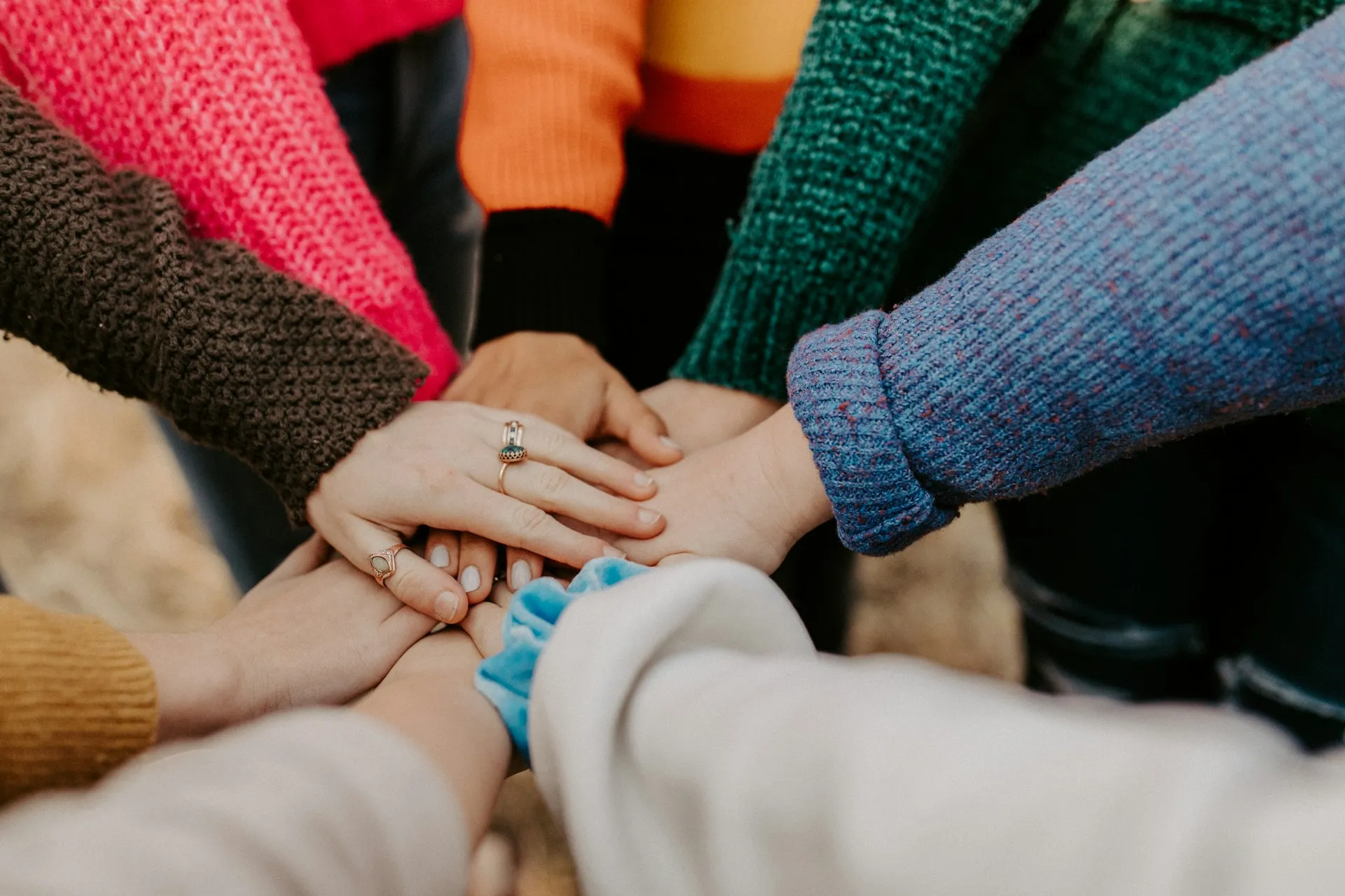 Community members putting their hands together in the middle
