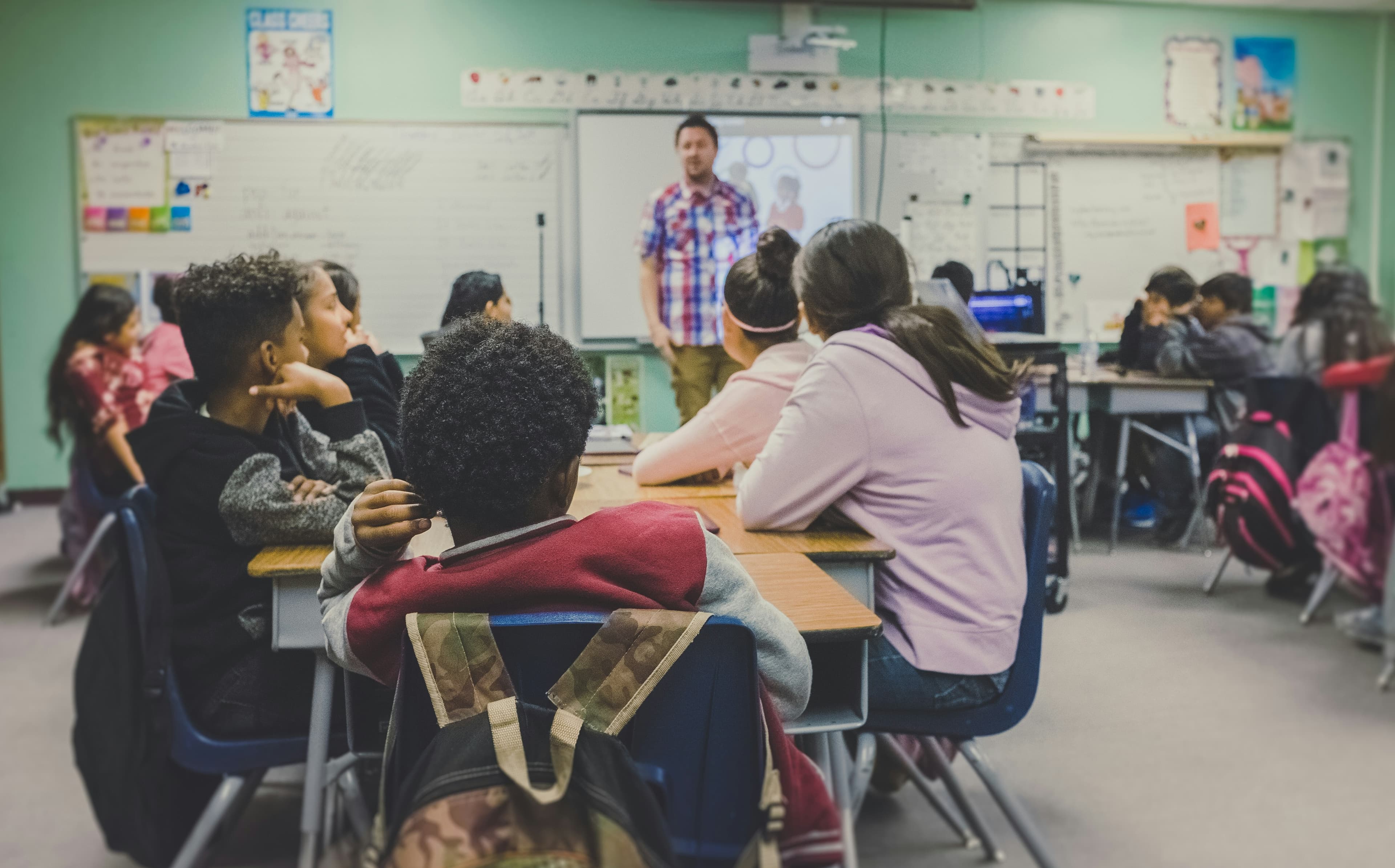 Teachers engaging in discussion with a student while sitting on couches in a classroom